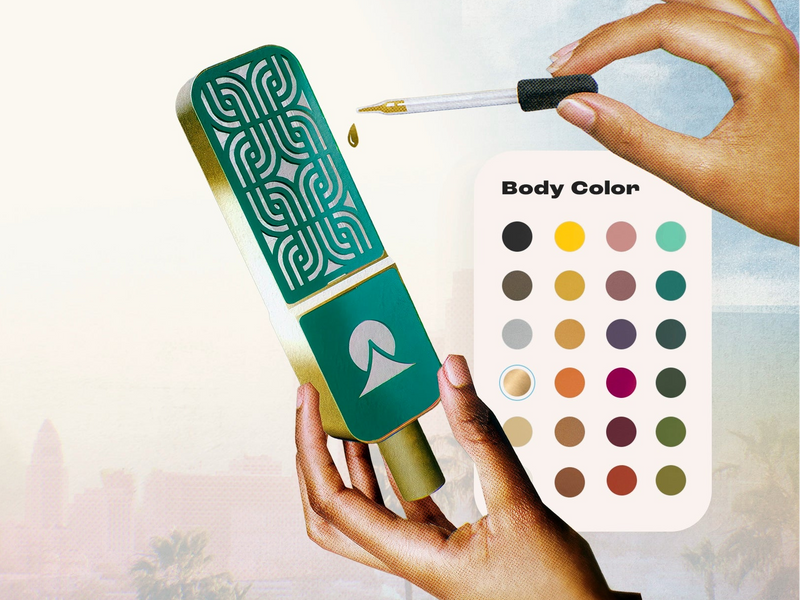 Green makeup applicator with intricate design held by a hand, against a blurred background.