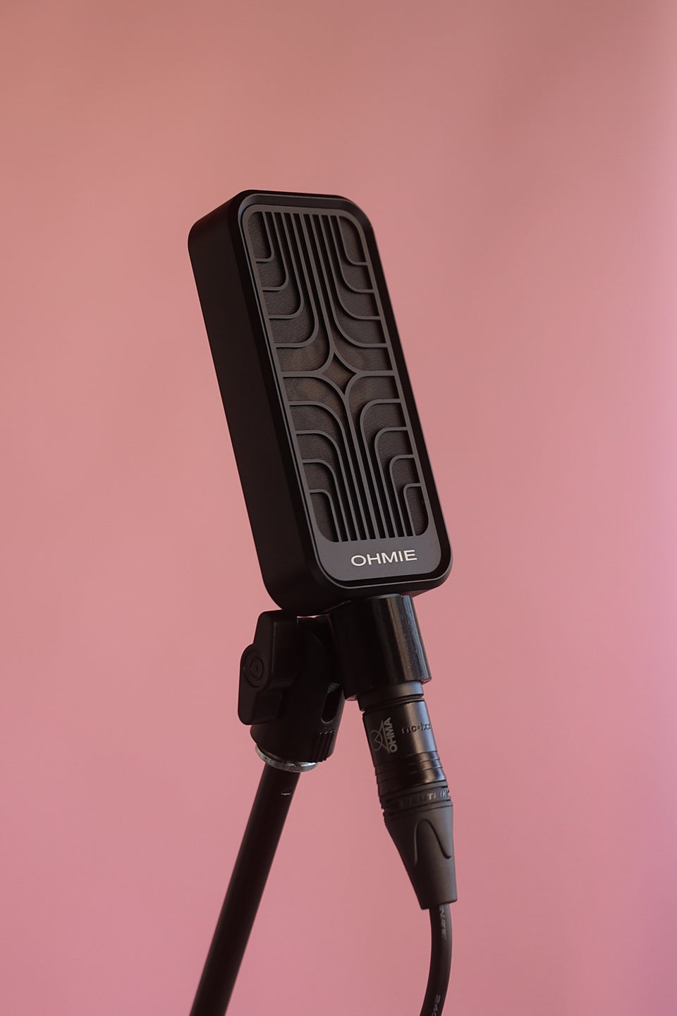 Close-up of the compact Ohmie microphone mounted in front of an amplifier